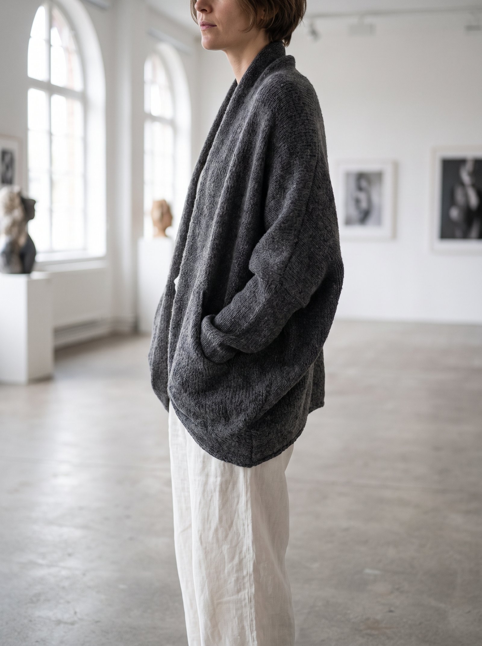 A slouchy charcoal cocoon cardigan shrug with deep hidden side pockets worn casually with linen trousers